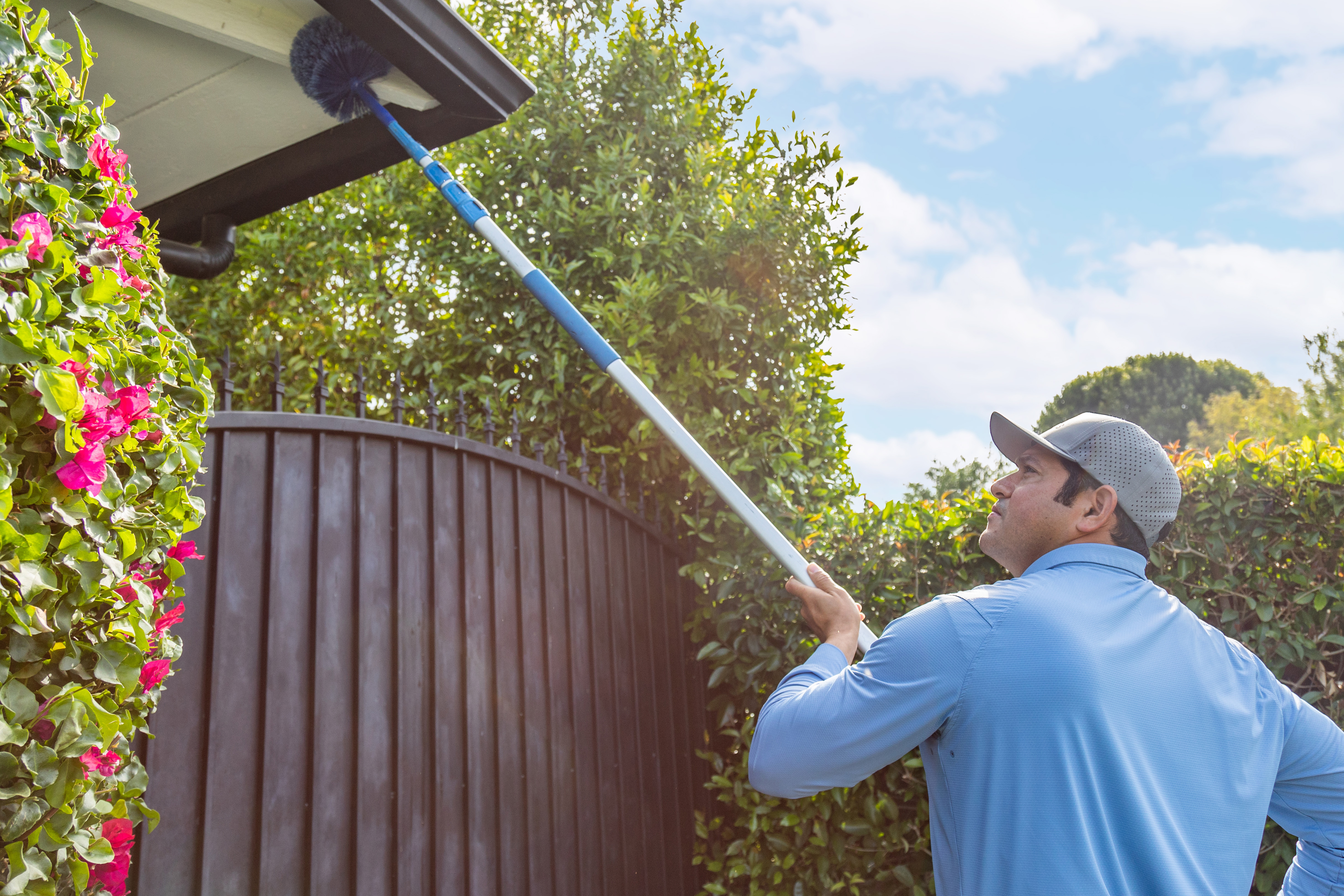 Technician treating exterior of home for pest prevention