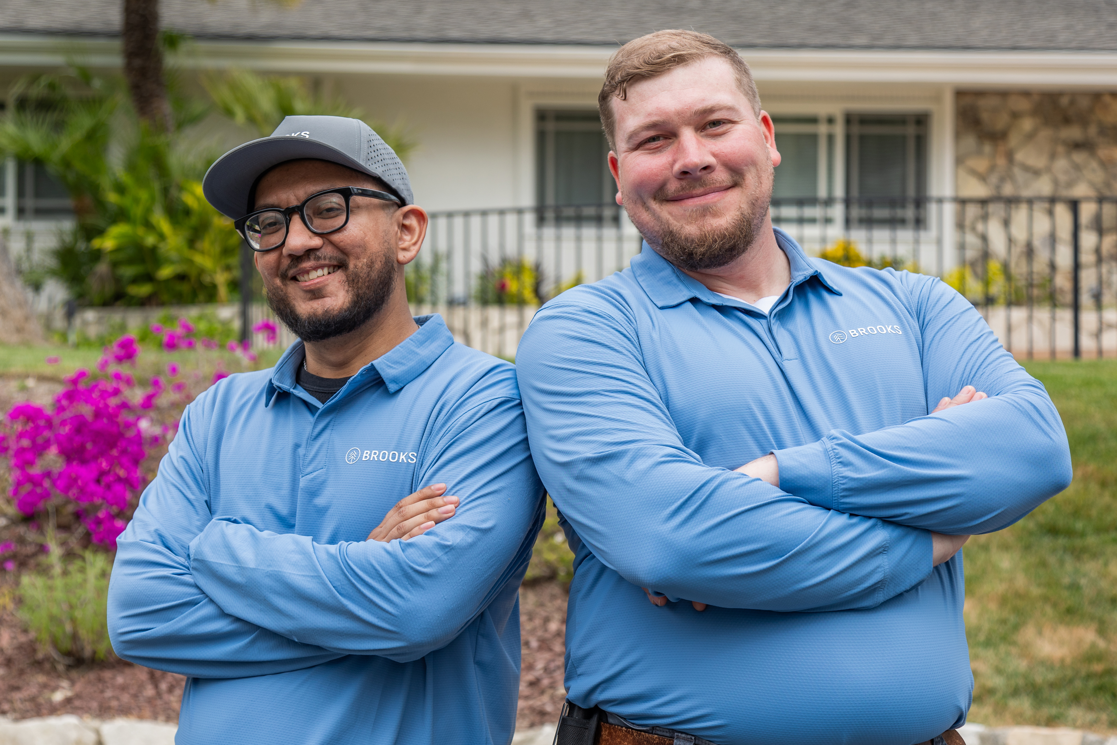 Two Brooks Pest Control technicians standing confidently together